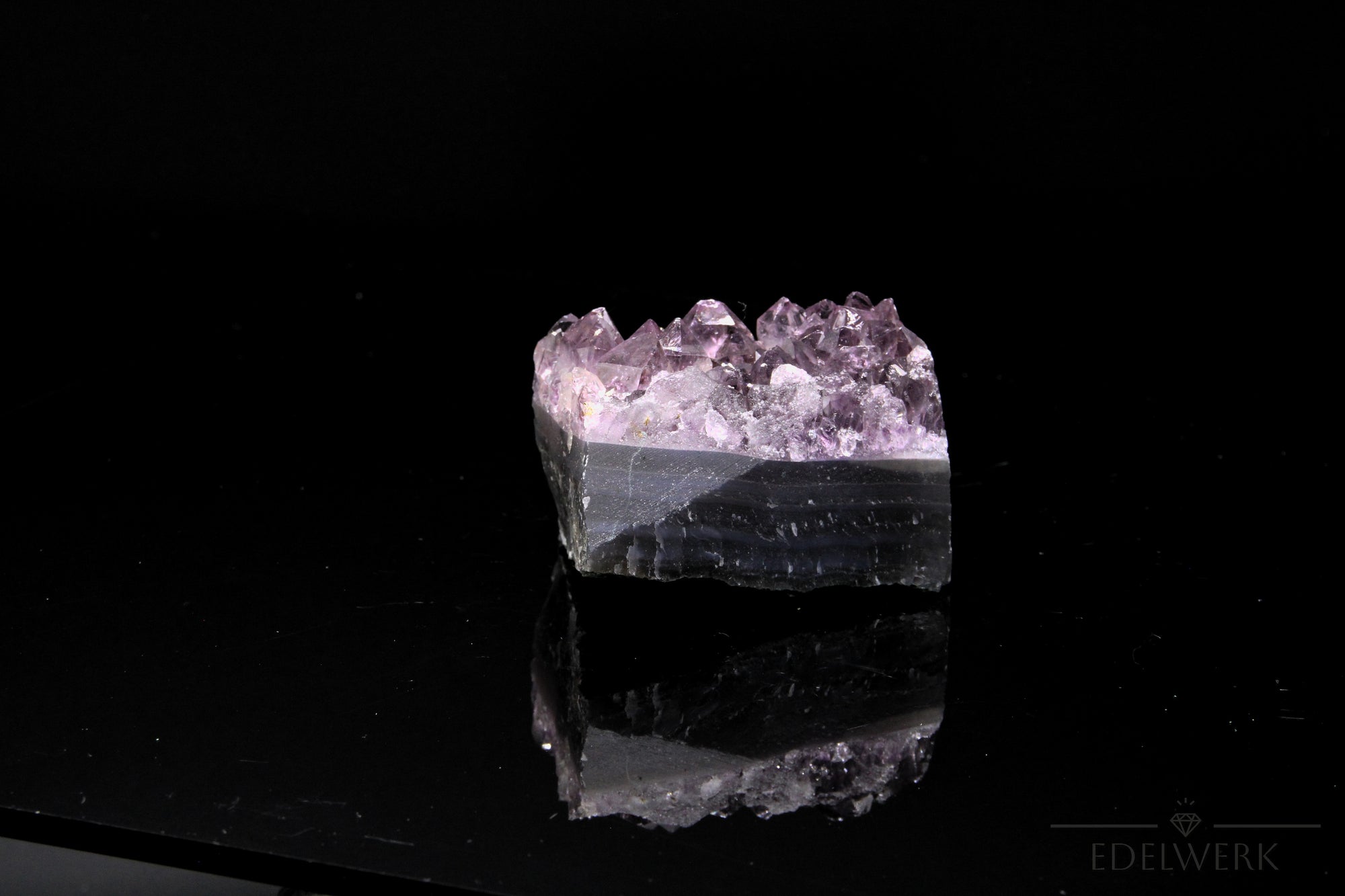 Violetter Amethyst Kristall, fördert intuitive Klarheit, violette glänzende Oberfläche.