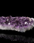 Tiefvioletter Amethyst Kristall, Heilstein für innere Balance, violette glänzende Form.