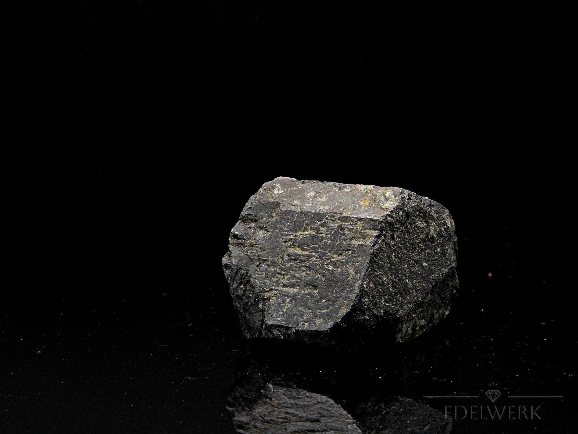 Strahlender Schwarzer Turmalin, Heilstein für innere Balance, glänzende schwarze Oberfläche.