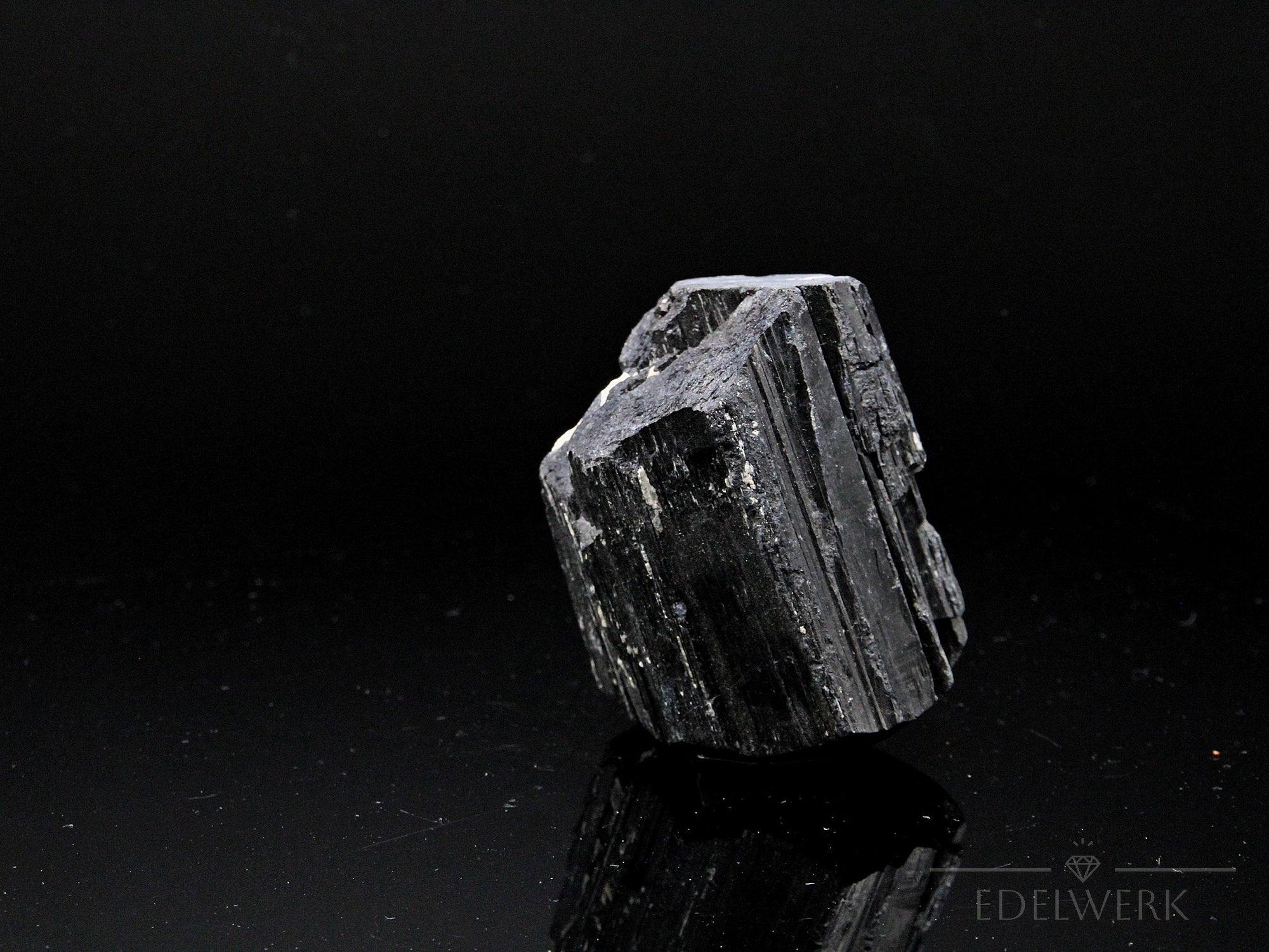 Schwarzer Turmalin Heilstein, fördert ruhige Energie, glänzende schwarze Struktur.