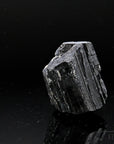 Schwarzer Turmalin Heilstein, fördert ruhige Energie, glänzende schwarze Struktur.