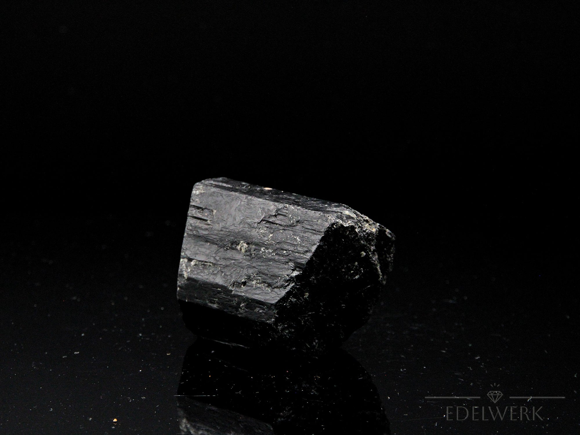 Schwarzer Turmalin Heilstein, fördert meditative Reinigung, schwarze glänzende Form.