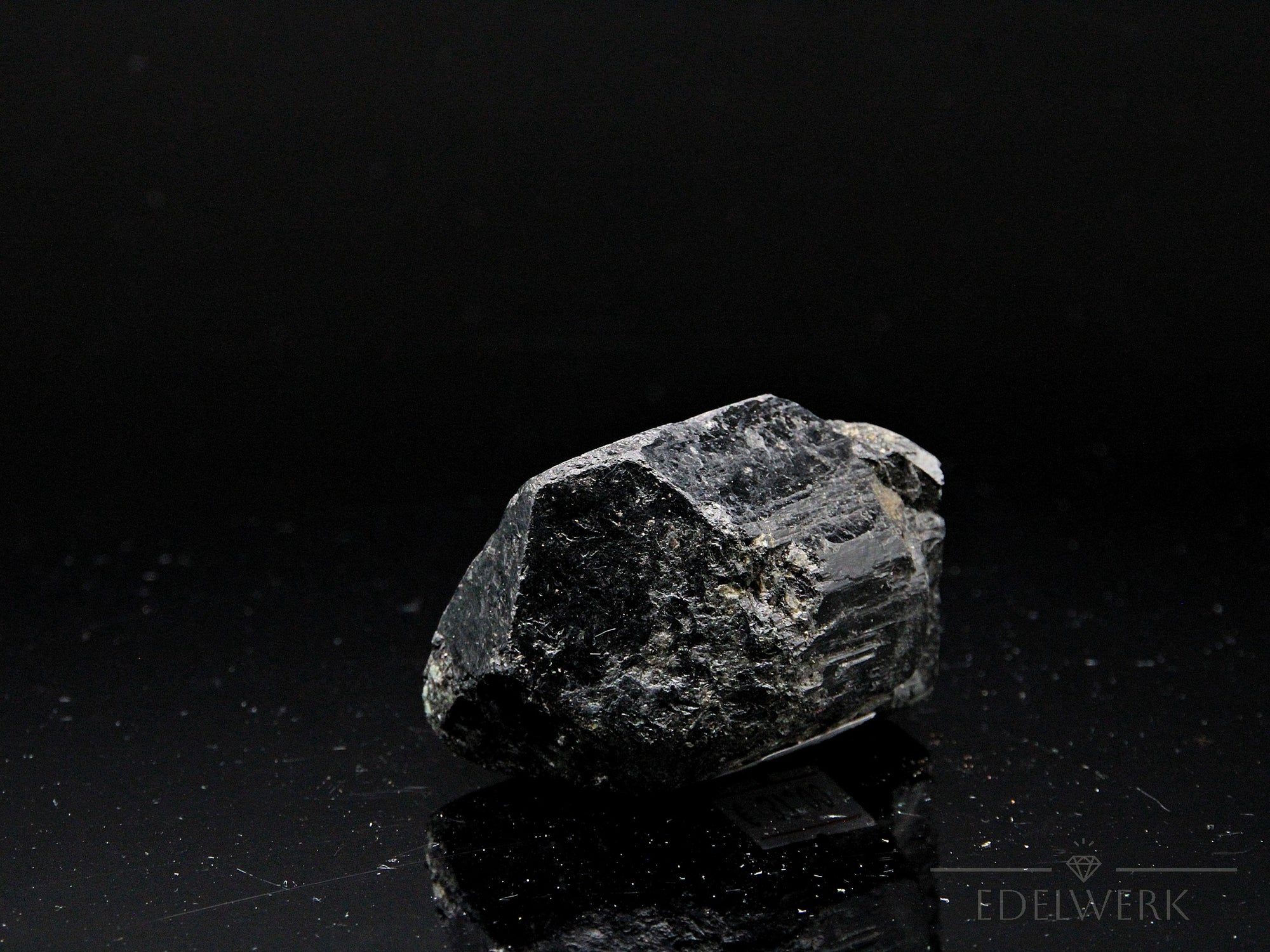 Schwarzer Turmalin, fördert schützende Harmonie, glänzende schwarze Kristalle.