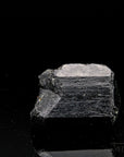 Schwarzer Turmalin, fördert schützende Energie, glänzende schwarze Oberfläche.