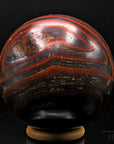 Tigeraugen Kugel Planet, Heilstein für spirituellen Schutz, glänzende gold-braune Form.