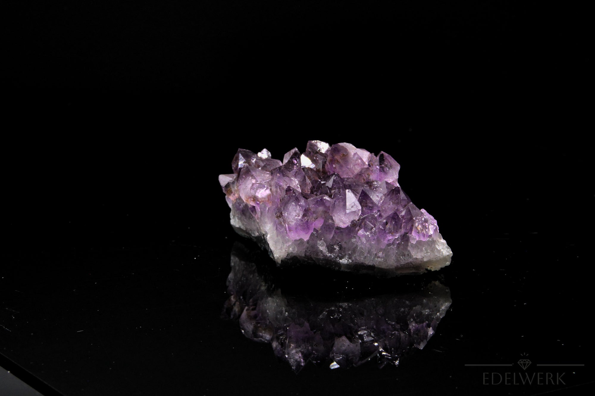Tiefvioletter Amethyst Kristall, Heilstein für innere Stärke, violette glänzende Form.