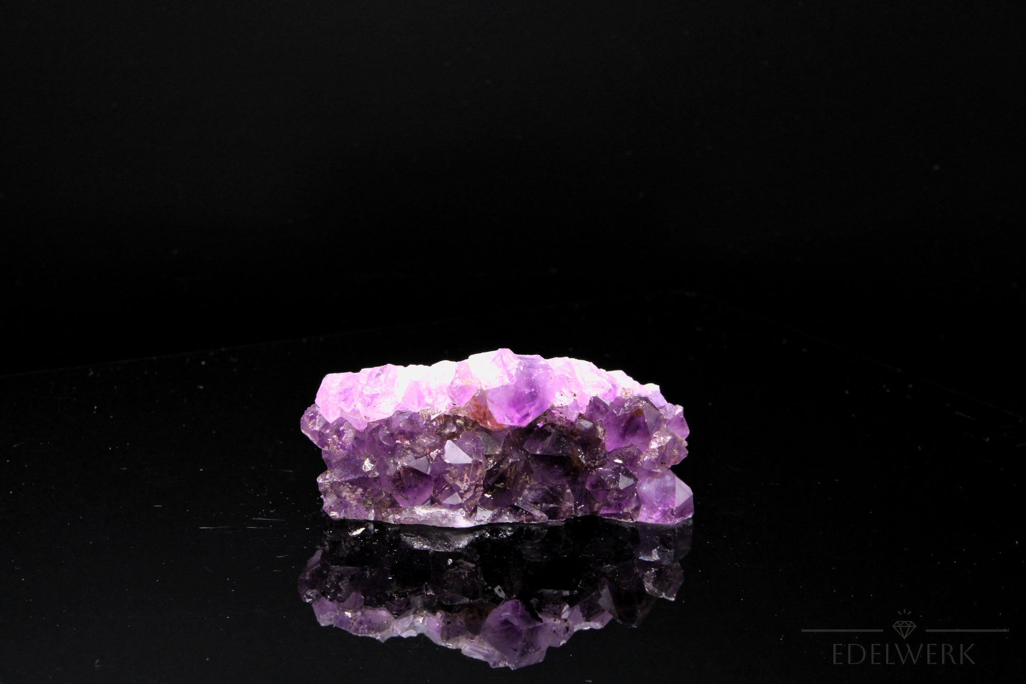 Strahlender Amethyst Kristall, Heilstein für innere Balance, violette strahlende Oberfläche.