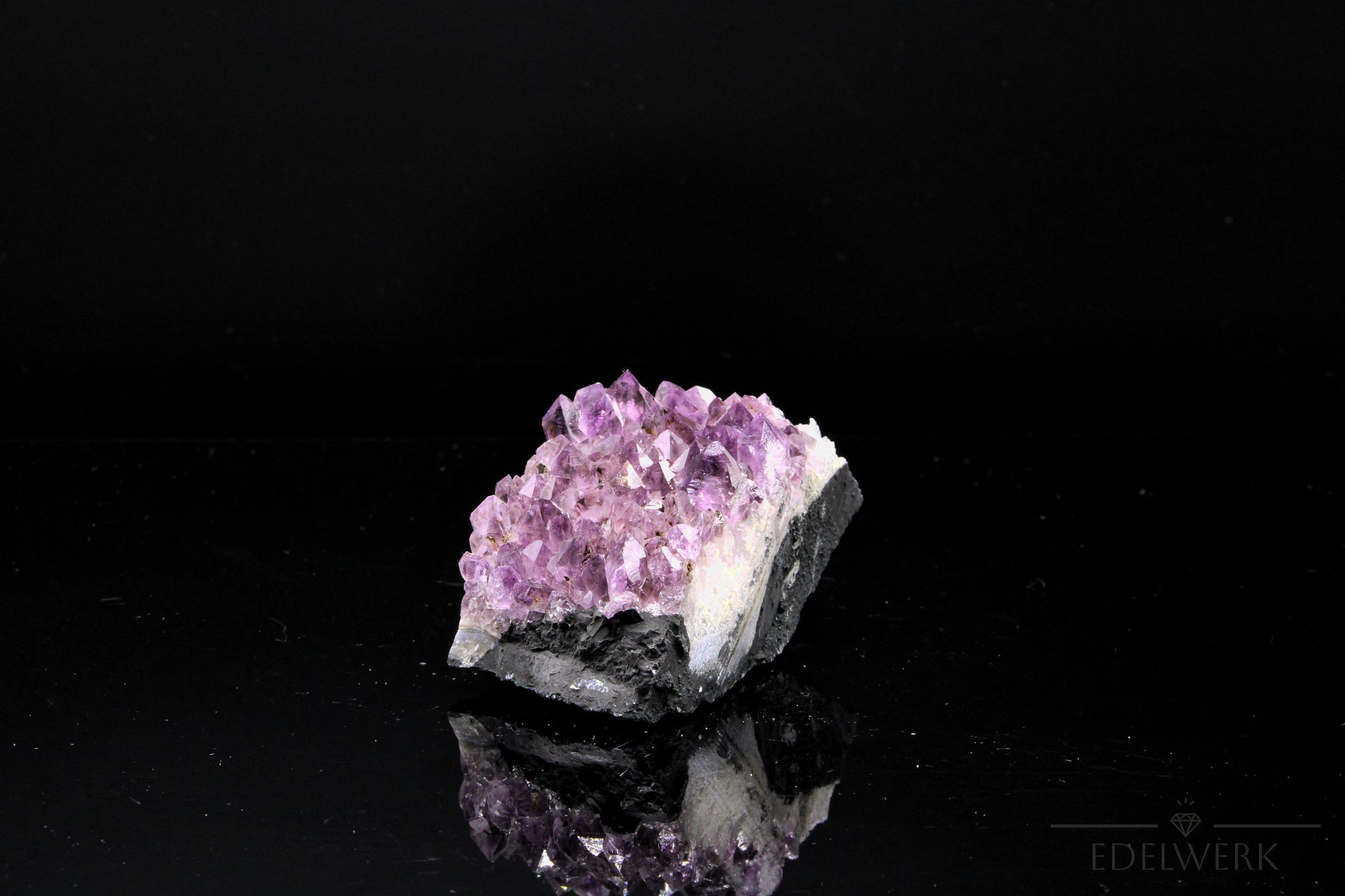 Strahlender Amethyst Kristall, Heilstein für innere Balance, violette strahlende Oberfläche.