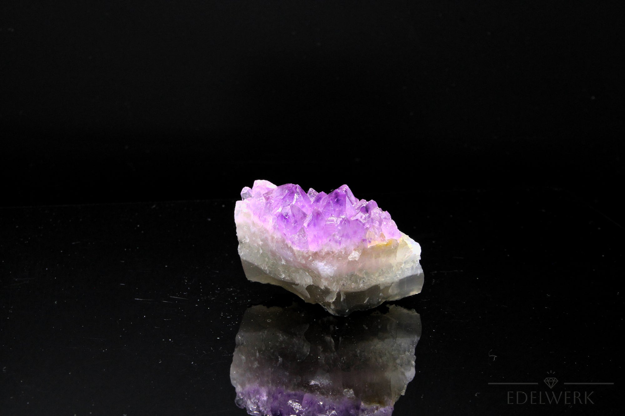Strahlender Amethyst Kristall, Heilstein für innere Balance, violette strahlende Oberfläche.