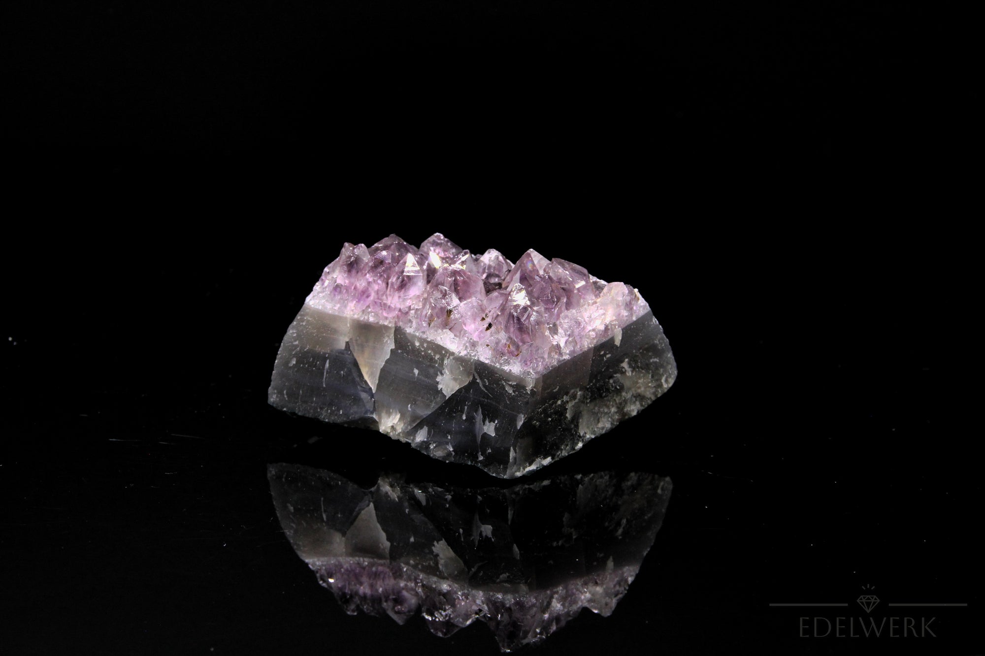 Violetter Amethyst Kristall, Heilstein für innere Ruhe, violette glänzende Form.