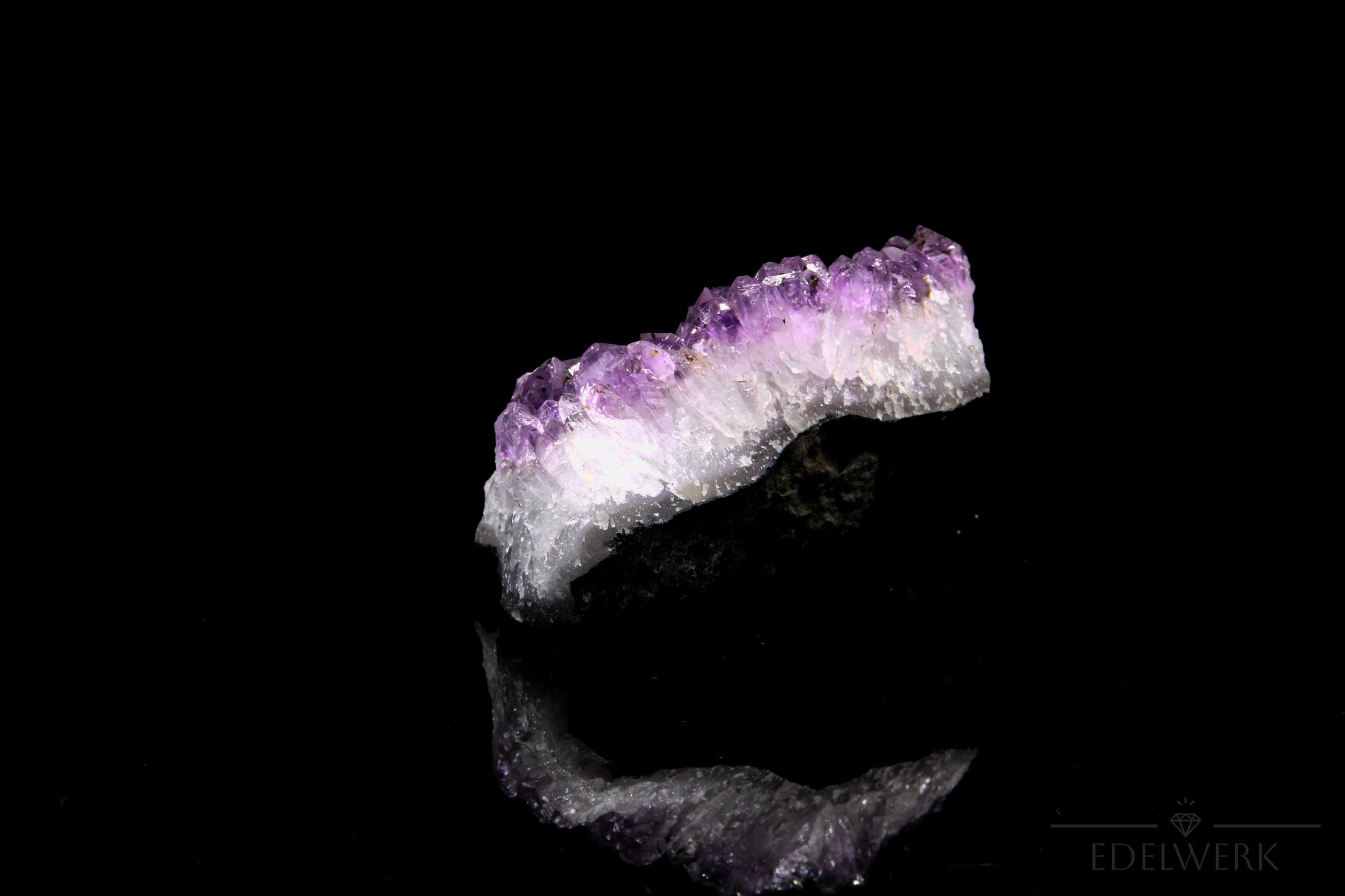 Tiefvioletter Amethyst Kristall, fördert energetische Harmonie, violette glänzende Oberfläche.