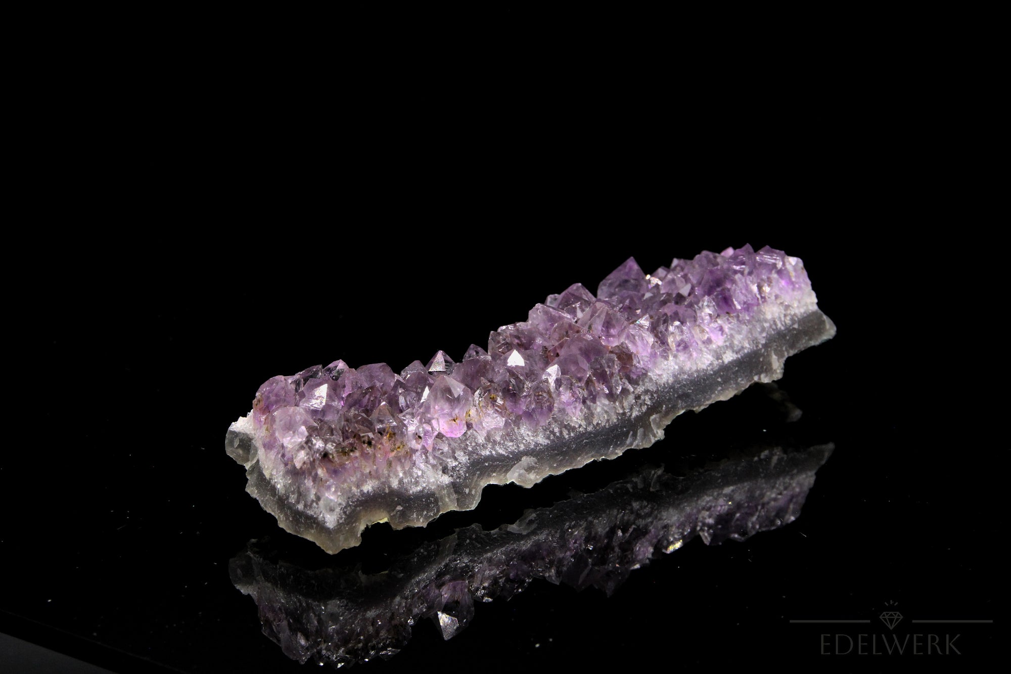 Strahlender Amethyst Kristall, Heilstein für innere Balance, violette strahlende Oberfläche.