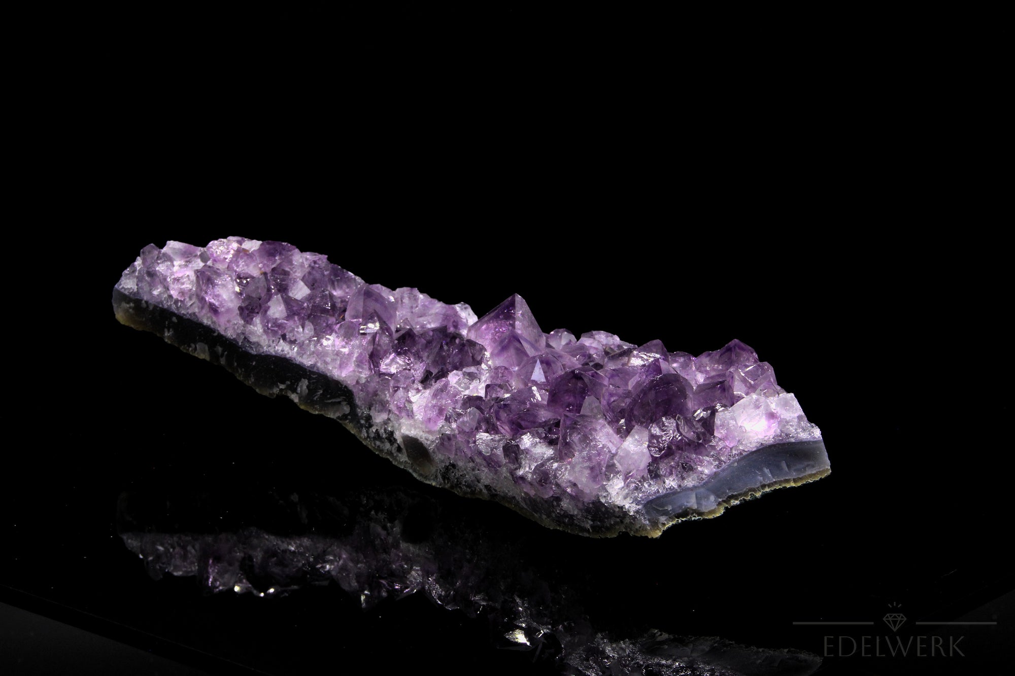 Tiefvioletter Amethyst Kristall, Heilstein für klare Meditation, violette glänzende Oberfläche.
