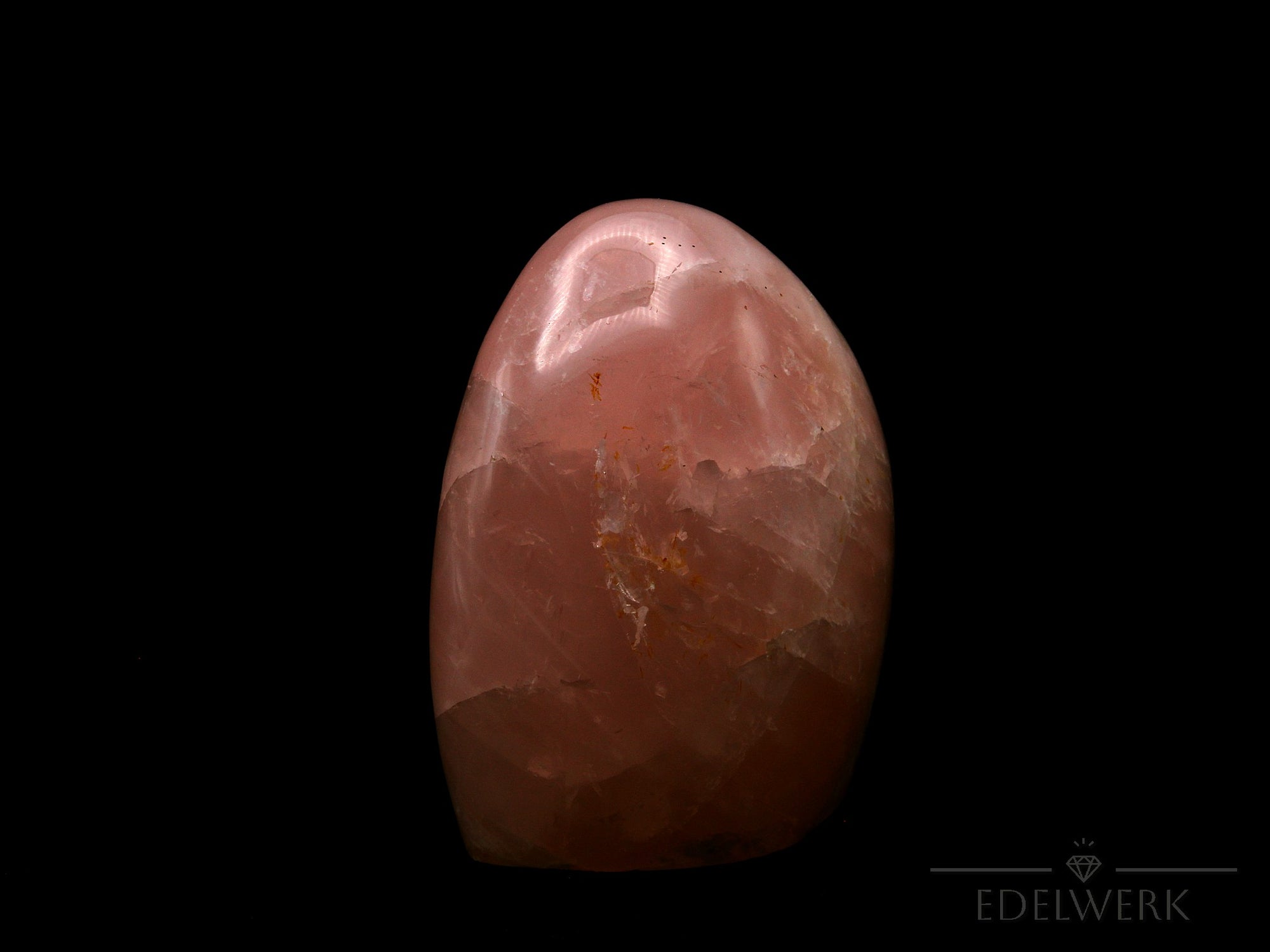 Strahlender Rosenquarz, Heilstein für spirituelle Ausgeglichenheit, rosa glänzende Form.