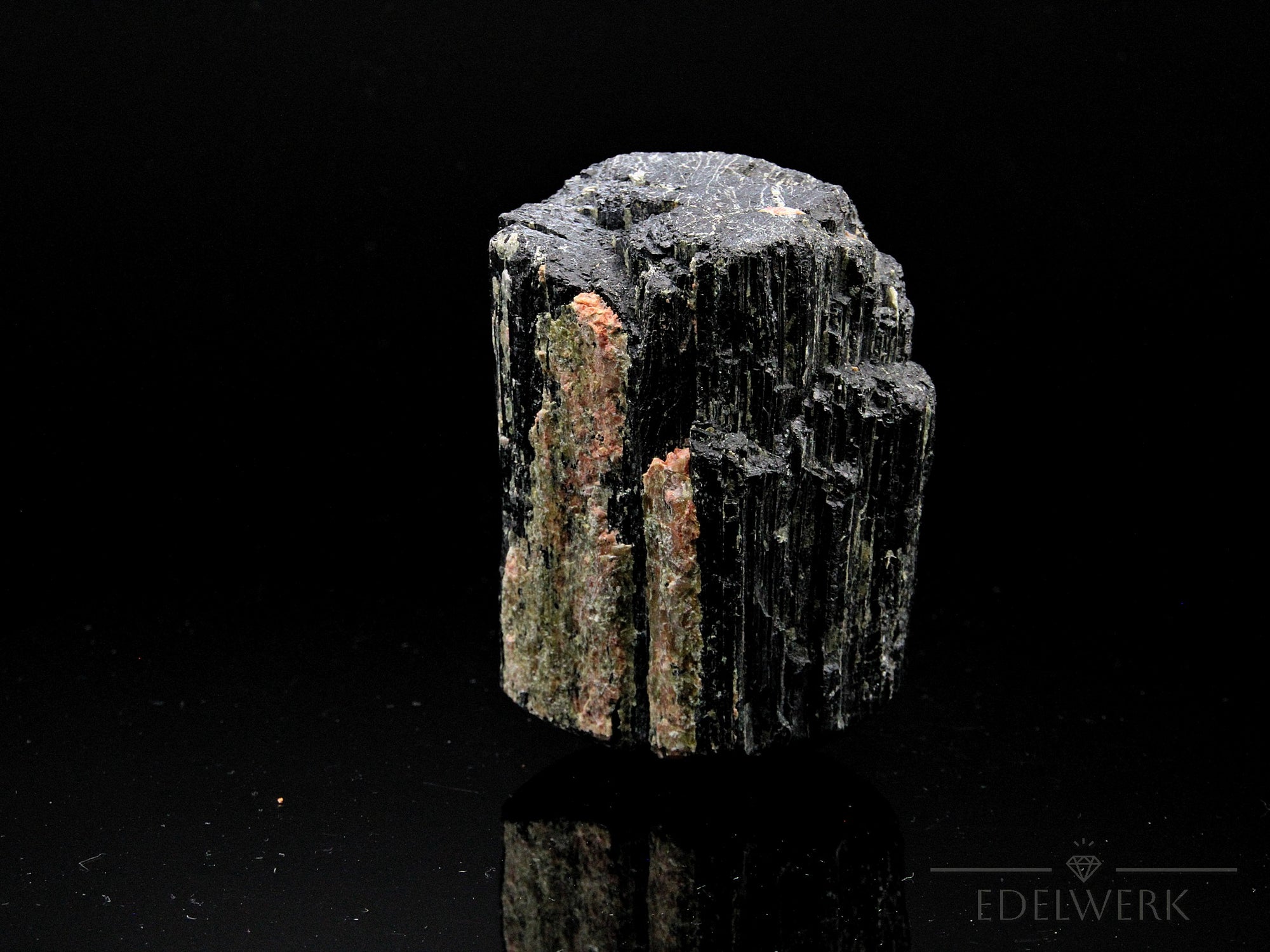 Schwarzer Turmalin Heilstein, Heilstein für spirituelle Balance, schwarze Oberfläche.