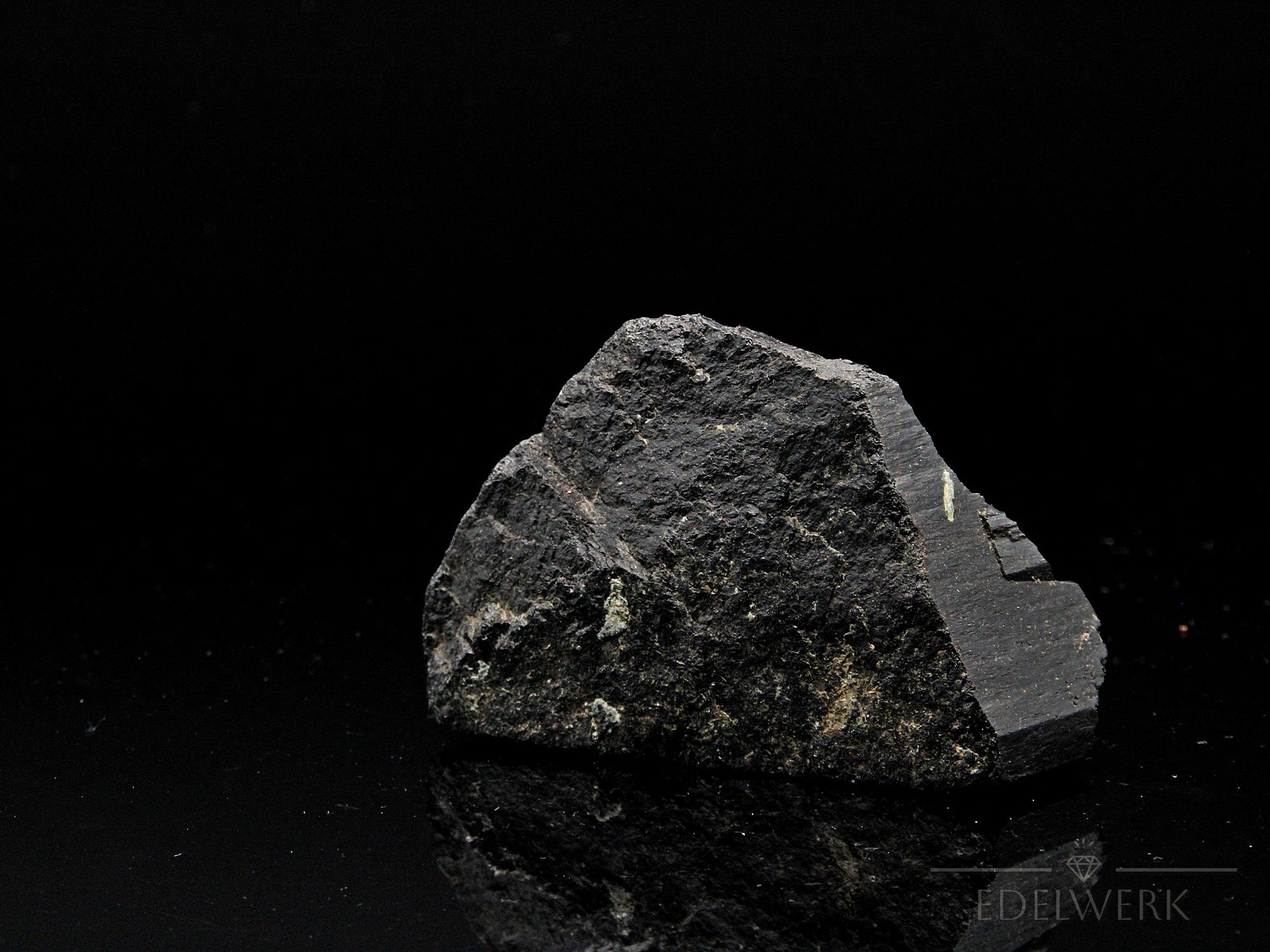 Strahlender Schwarzer Turmalin, Heilstein für innere Balance, glänzende schwarze Oberfläche.